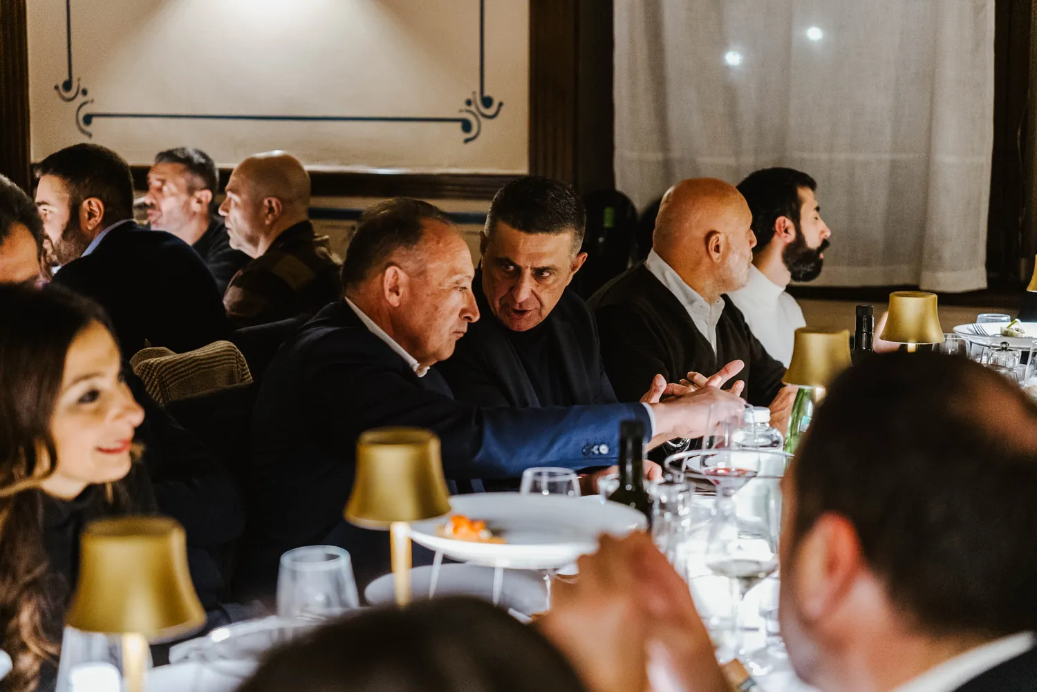Giancarlo De Leonardo seduto a tavola, in conversazione con ristoratori e albergatori